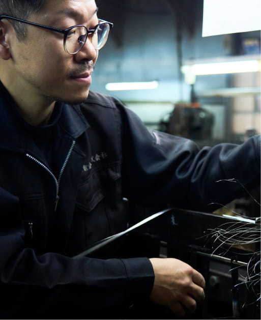 真剣な表情で製造機械を操作する男性